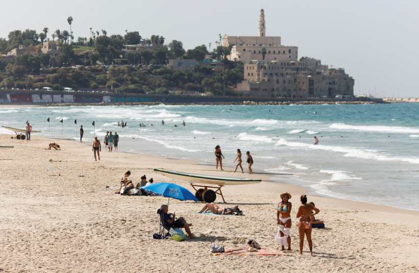  Revelers enjoy a Tel Aviv beach near Jaffa. (photo credit: AMIR COHEN/REUTERS)