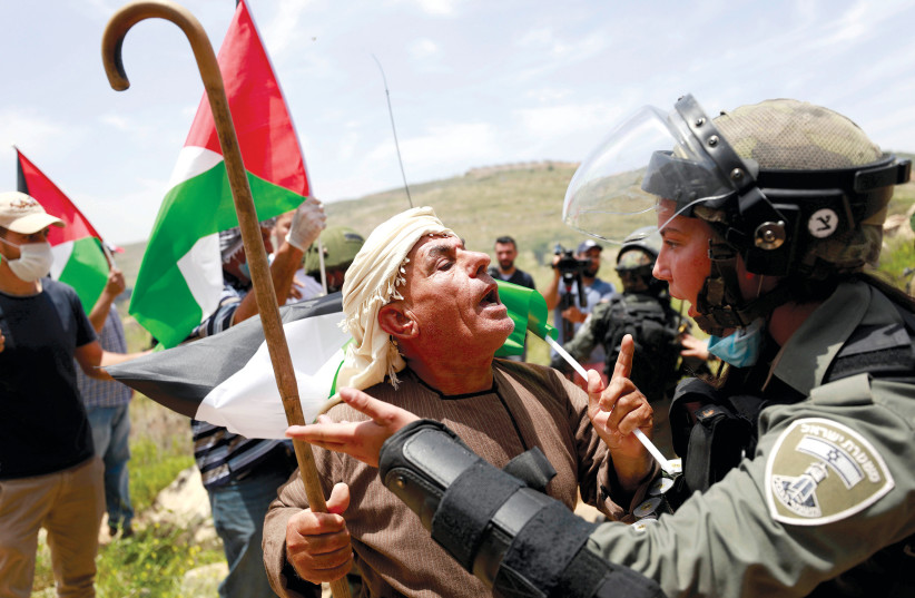  A Palestinian argues with an Israeli border policewoman during a protest in the village of Sawiya near Nablus on the so-called Nakba Day. (photo credit: MOHAMAD TOROKMAN/REUTERS)