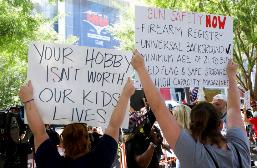 People protest against gun laws outside the National Rifle Association (NRA) annual convention in Houston, Texas, US, May 27, 2022. (credit: REUTERS/DANIEL KRAMER)