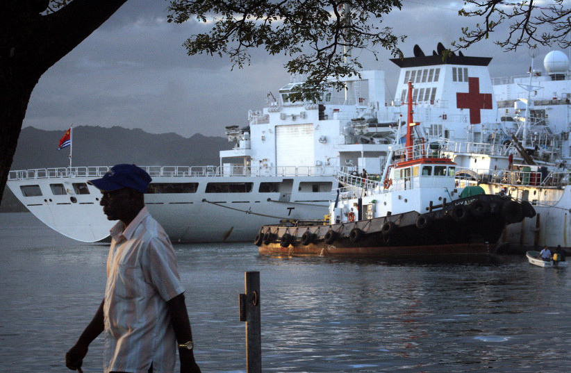   A man walks past a Chinese hospital ship called The Peace Ark, which offers free health care as it sails through the South Pacific, as it sits moored in the harbour of the Fiji capital of Suva August 24, 2014 (photo credit: REUTERS/LINCOLN FEAST)