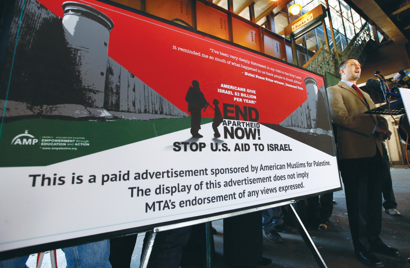  HATEM BAZIAN, chairman of American Muslims for Palestine, speaks in 2013 alongside one of the organization’s advertisements at a train station in New York City, accusing Israel of apartheid and calling for a stop to US aid. (photo credit: Mike Segar/Reuters)