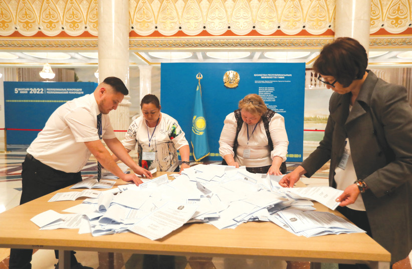  MEMBERS OF a local electoral commission organize ballot papers after polls closed for the constitutional referendum, at a polling station in Nur-Sultan, Kazakhstan, on Sunday. (photo credit: PAVEL MIKHEYEV/REUTERS)