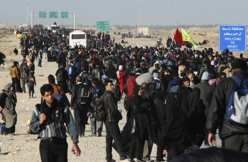  Iranian Shi'ite pilgrims walk on a road after entering Iraq through Wasit province at the Iraq-Iran border crossing, December 8, 2014. (credit: REUTERS)