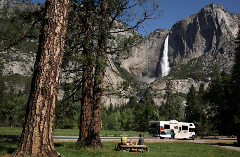 A family has a picnic in view of Upper Yosemite Falls in Yosemite National Park, California May 17, 2009. (photo credit: REUTERS/Robert Galbraith/File Photo)
