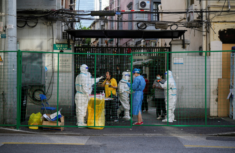 A resident gets tested for the coronavirus disease (COVID-19) at a sealed area, after the lockdown placed to curb the COVID-19 outbreak was lifted in Shanghai, China June 8, 2022. (photo credit: REUTERS/ALY SONG)