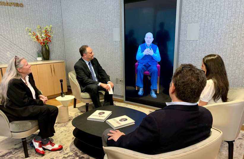  Second Gentleman Doug Emhoff, second from left, speaks to an interactive artificial intelligence video of Holocaust survivor Pinchas Gutter. (photo credit: JACOB GURVIS/JTA)