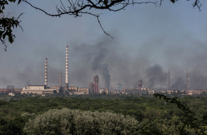 Smoke rises after a military strike on a compound of Sievierodonetsk's Azot Chemical Plant, amid Russia's attack on Ukraine, in the town of Lysychansk, Luhansk region, Ukraine, June 10, 2022. (photo credit: REUTERS/OLEKSANDR RATUSHNIAK)