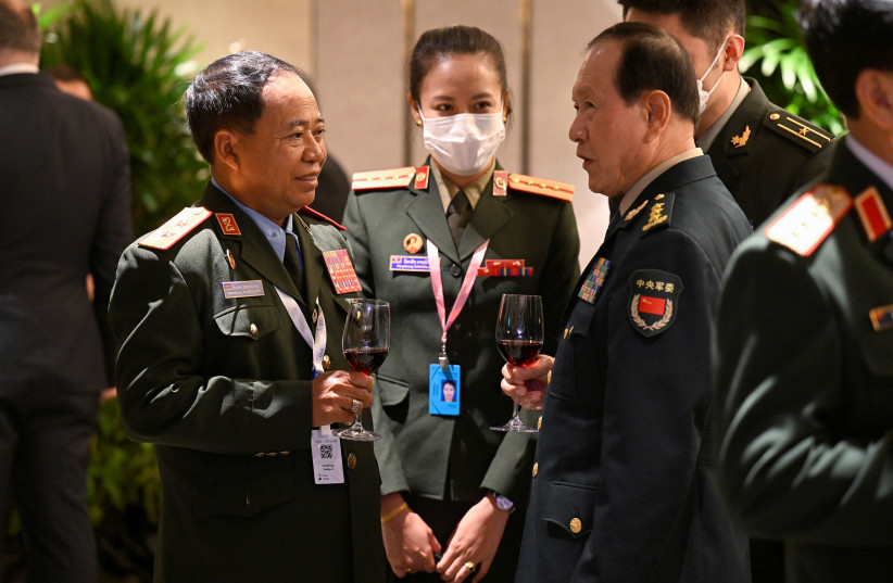 Laos' Major General Chanthong Sonetaath speaks to China's State Councilor and Defense Minister General Wei Fenghe before the ministerial working lunch during the 19th Shangri-La Dialogue in Singapore, June 11, 2022. (photo credit: REUTERS/CAROLINE CHIA)