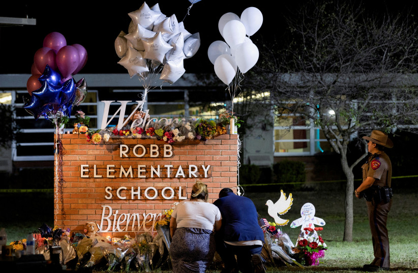   Stephanie and Michael Chavez of San Antonio pay their respects at a makeshift memorial outside Robb Elementary School, the site of a mass shooting, in Uvalde, Texas, US, May 25, 2022. (photo credit: REUTERS/NURI VALLBONA)