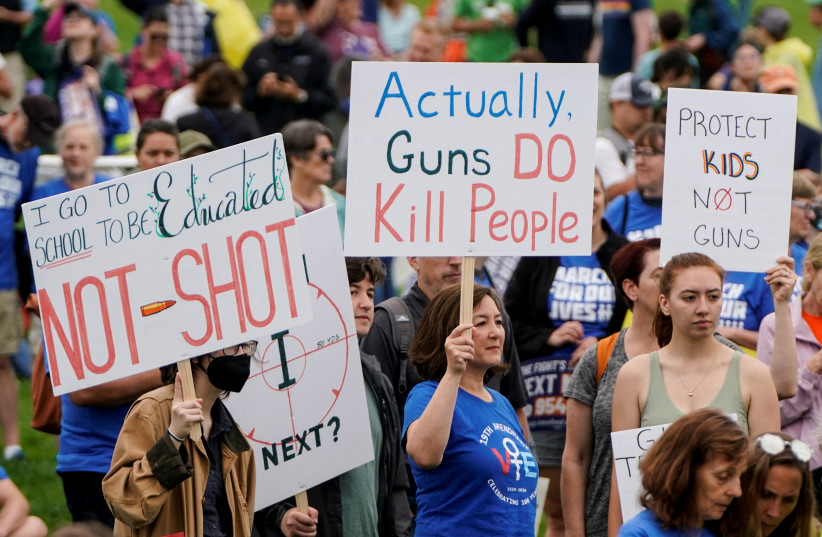   Demonstrators hold placards as they take part in the 'March for Our Lives', one of a series of nationwide protests against gun violence, in Washington, D.C., US, June 11, 2022. (photo credit: REUTERS/JOSHUA ROBERTS/FILE PHOTO)