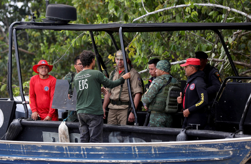  Police officers and rescue team members sit on a boat during the search operation for British journalist Dom Phillips and indigenous expert Bruno Pereira, who went missing while reporting in a remote and lawless part of the Amazon rainforest, near the border with Peru, in Atalaia do Norte. (photo credit: REUTERS/BRUNO KELLY)
