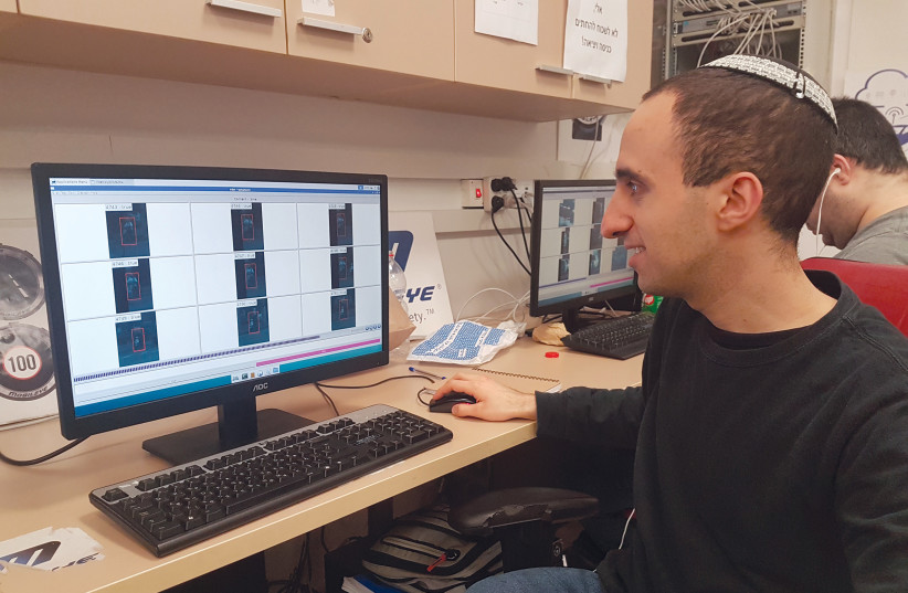  Jonathan Trauner, a Mobileye employee through SHEKEL’s vocational program, at his desk at Mobileye’s Jerusalem headquarters (credit: SHEKEL)