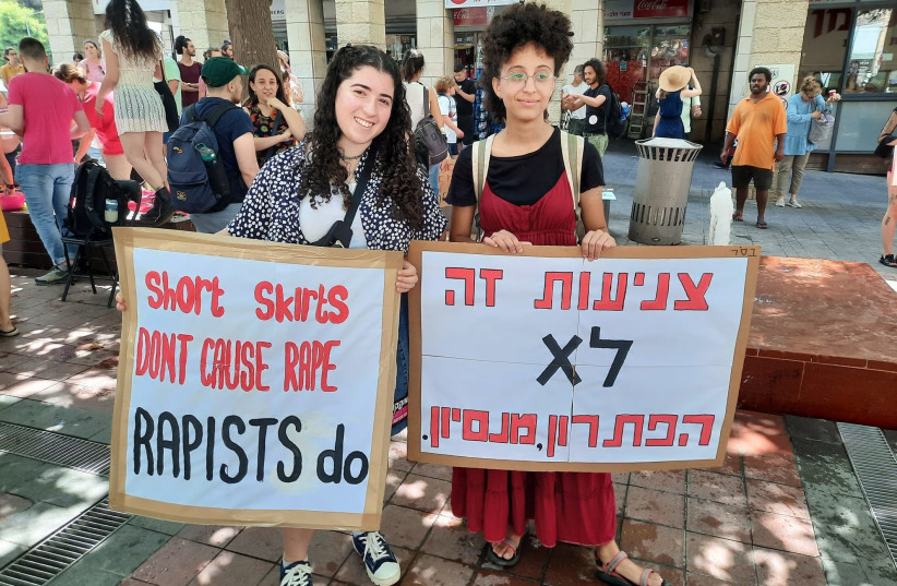  Participants at the Jerusalem SlutWalk hold signs reading ''short skirts don't cause rape, rapists do,'' and ''modesty is not the solution, from experience,'' June 17, 2022 (credit: EVE YOUNG)