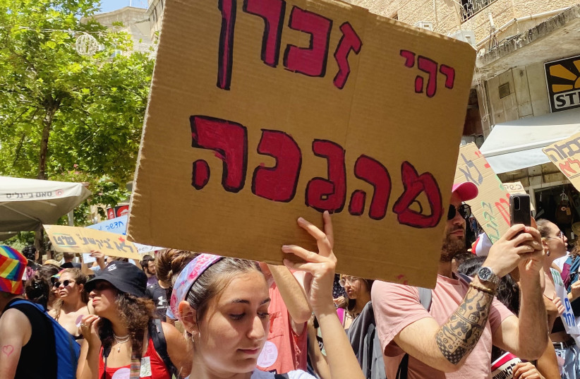  A participant at the Jerusalem SlutWalk holding a sign reading "may their memory be a revolution," June 17, 2022 (photo credit: SHIRA SILKOFF)