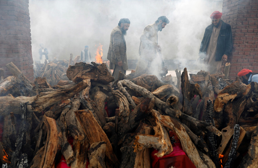  Afghan Sikh men light the funeral pyre for the victims who were killed during yesterday's attack at Sikh religious complex during a funeral in Kabul, Afghanistan March 26, 2020 (photo credit: REUTERS/MOHAMMAD ISMAIL)