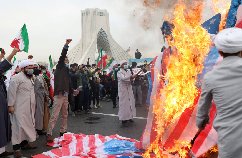  Iranian clerics set fire to American flag during the 43rd anniversary of the Islamic Revolution in Tehran, Iran, February 11, 2022. (credit: MAJID ASGARIPOUR/WANA/REUTERS)
