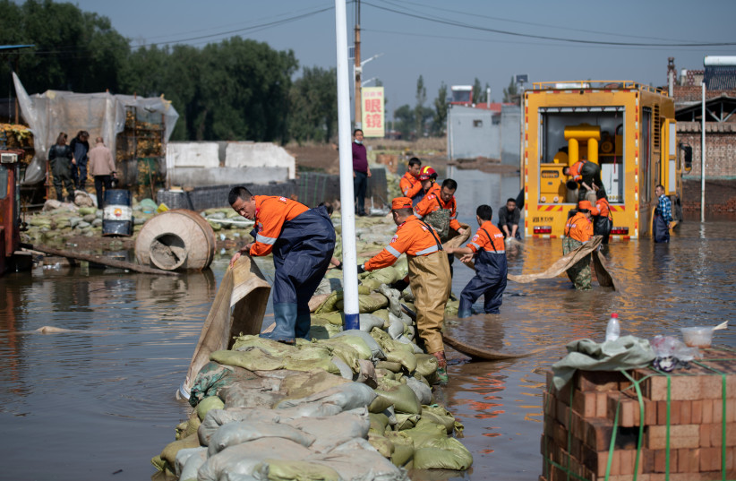  Rescue workers use a pump to drain off floodwater following heavy rainfall at a village in Jiexiu city, Shanxi province, China October 11, 2021. (photo credit: CNSPHOTO VIA REUTERS)