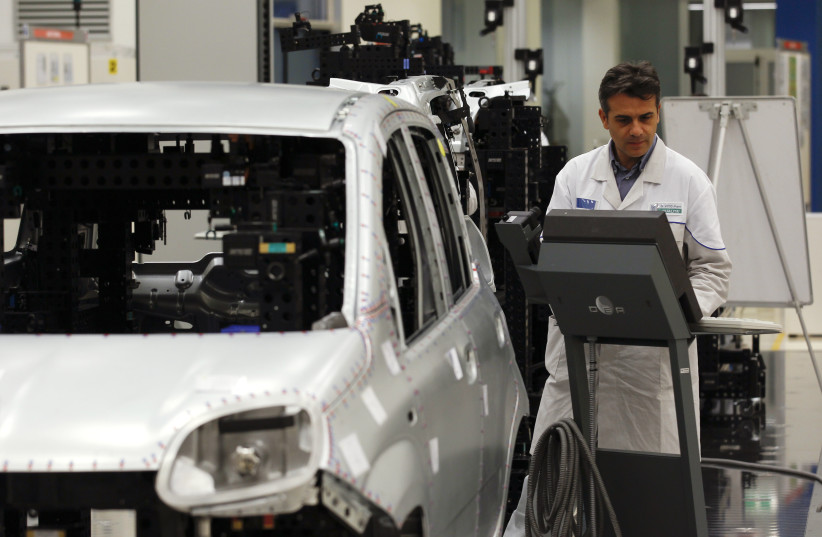  An employee of Fiat performs a quality control check on the new Panda car at the Fiat plant in Pomigliano D'Arco, near Naples (photo credit: REUTERS)
