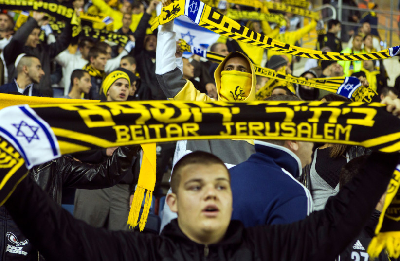  Fans of Beitar Jerusalem shout slogans during a match against Bnei Sakhnin as part of the Israeli Premier League, at Teddy Stadium in Jerusalem February 10, 2013  (photo credit: REUTERS/NIR ELIAS)