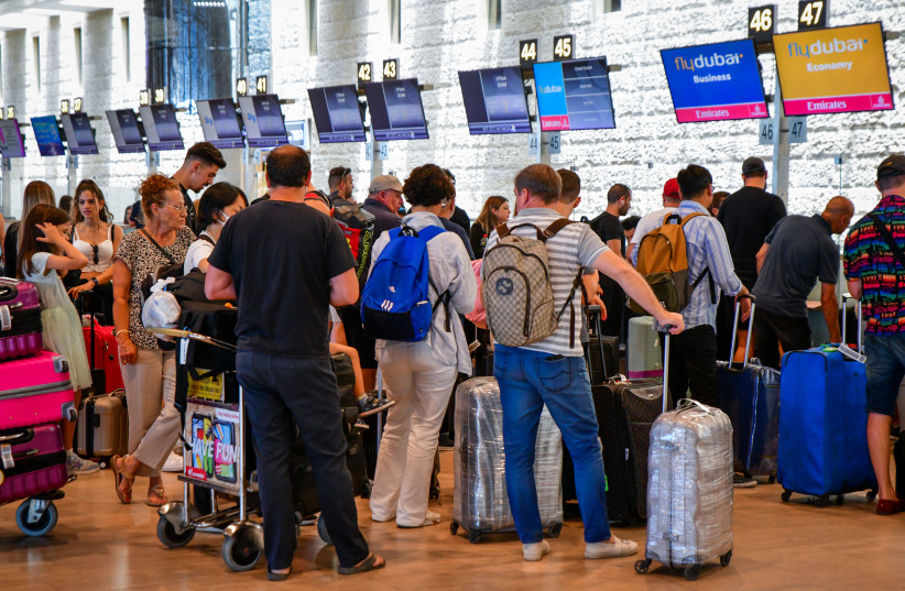  Travelers stand in line to check-in at Ben Gurion International Airport, on June 14, 2022. (photo credit: AVSHALOM SASSONI/FLASH90)