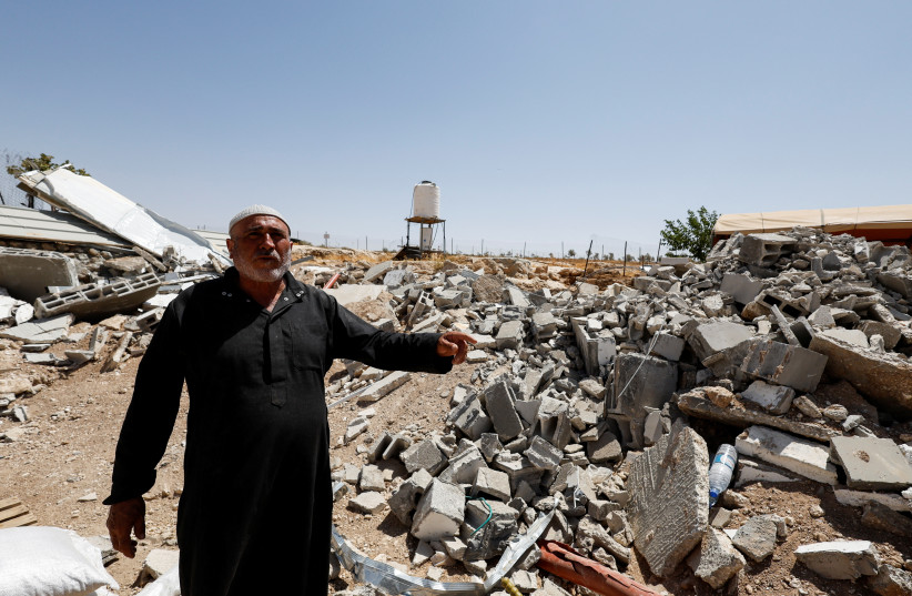  Palestinian Mahmoud Najajreh points at his demolished house, in Masafer Yatta, South of Hebron, in the West Bank, May 31, 2022.  (photo credit: MUSSA QAWASMA/REUTERS)
