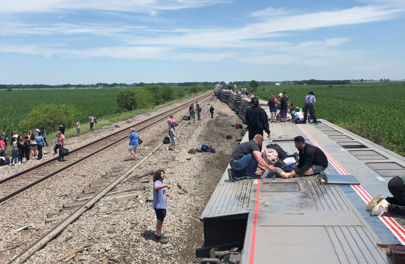  People exit from an Amtrak train that derailed after hitting a dump truck at an uncontrolled crossing, near Mendon, Missouri, US, June 27, 2022 in this picture obtained from social media. (photo credit: Dax McDonald/via REUTERS)