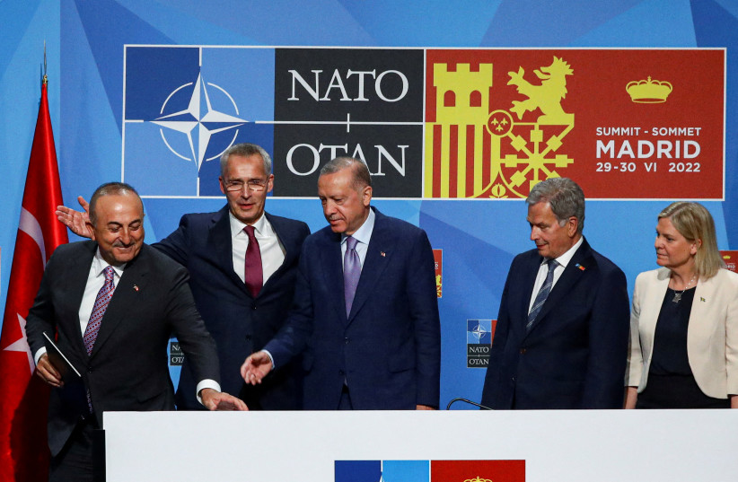  Turkish President Tayyip Erdogan, Sweden's Prime Minister Magdalena Andersson, NATO Secretary General Jens Stoltenberga, Finland's President Sauli Niinisto and Turkish Foreign Minister Mevlut Cavusoglu react after signing a document during a NATO summit in Madrid, Spain, June 28, 2022. (photo credit: Violeta Santos Moura/Reuters)