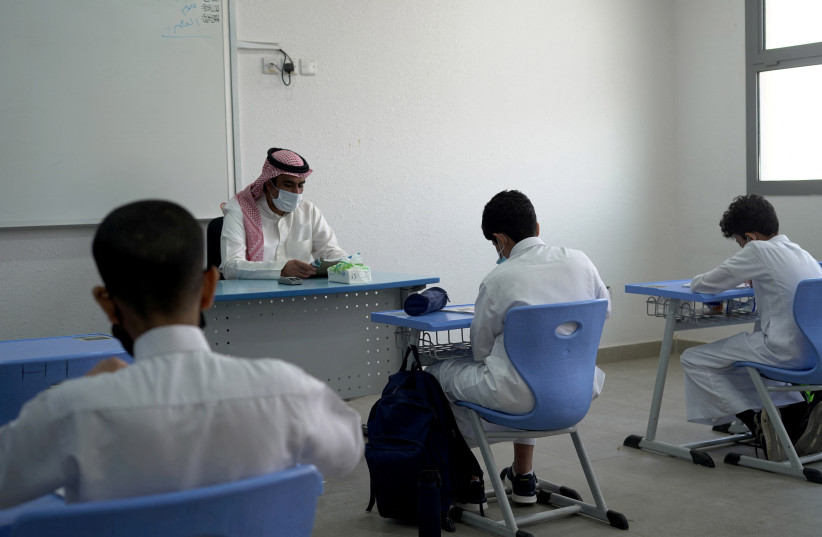  A Saudi teacher wearing a face mask teaches a class at a school in Riyadh, Saudi Arabia August 30, 2021 (photo credit: REUTERS/MOHAMMED BENMANSOUR)