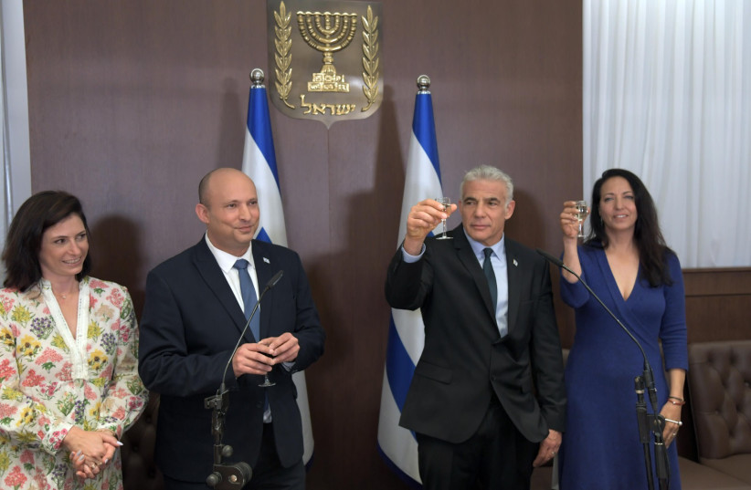 Bennett, Lapid and their families participated in a small ceremony for Lapid's transition to prime minister. (photo credit: CHAIM TZACH/GPO)