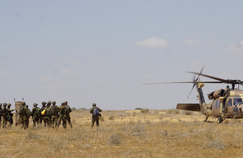  IDF TROOPS emerge from a helicopter as part of a drill in which they simulated evacuating wounded. (photo credit: SETH J. FRANTZMAN)