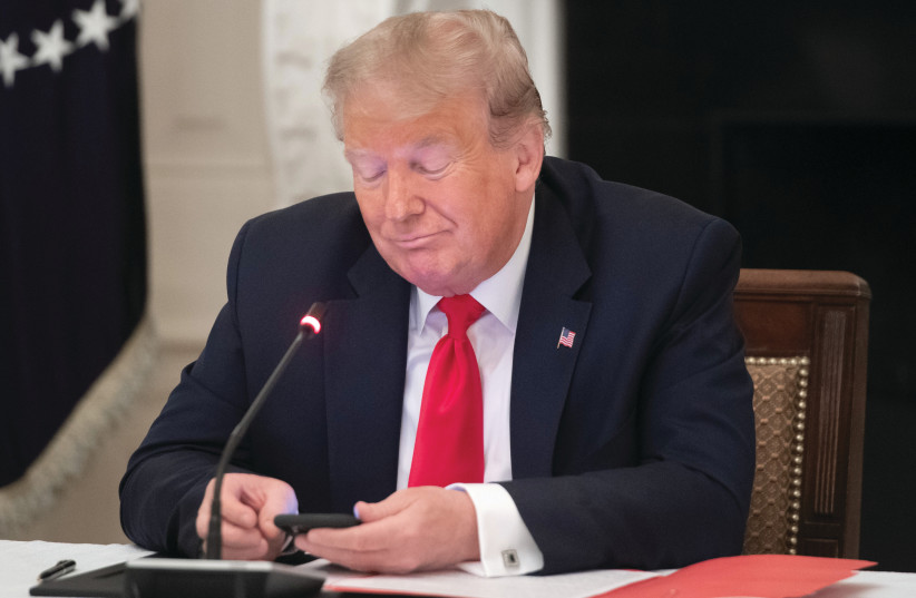  ‘MR. PRESIDENT, I work for you 24/7. Please call whenever you want’: Donald Trump (R) on his phone in the White House in Washington, 2020.  (photo credit: Saul Loeb/AFP via Getty Images)