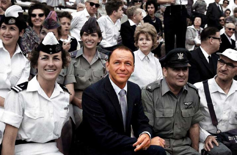 Frank Sinatra watching an IDF parade during a visit to Israel in 1962 (credit: MEITAR COLLECTION/PRITZKER FAMILY NATIONAL PHOTOGRAPH COLLECTION/NLI. COLORIZATION: MYHERITAGE)