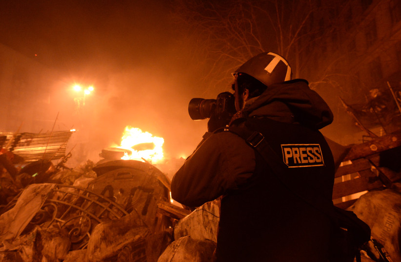  Journalist documenting clashes. (photo credit: Wikimedia Commons)
