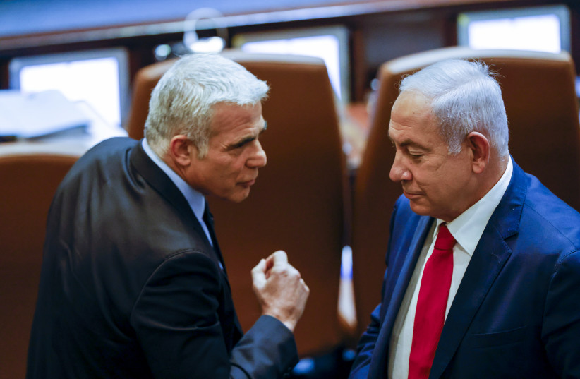  Israeli foreign minister and Head of the Yesh Atid party Yair Lapid walks next to Head of opposition and head of the Likud party Benjamin Netanyahu at the assembly hall for a special session in memory of Israel's first Prime Minister David Ben Gurion, on November 8, 2021.  (credit: OLIVIER FITOUSSI/FLASH90)