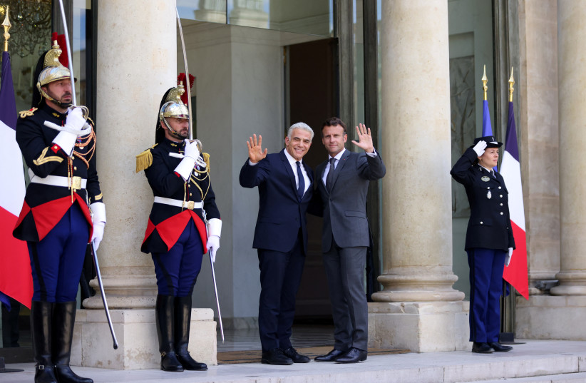  French President Emmanuel Macron welcomes Israeli Prime Minister Yair Lapid as he arrives for a meeting at the Elysee Palace in Paris, France, July 5, 2022. (photo credit: REUTERS/Johanna Geron)