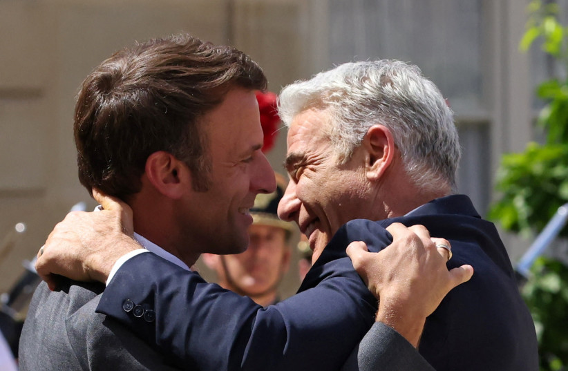French President Emmanuel Macron welcomes Israeli Prime Minister Yair Lapid as he arrives for a meeting at the Elysee Palace in Paris, France, July 5, 2022. (credit: REUTERS/Johanna Geron)