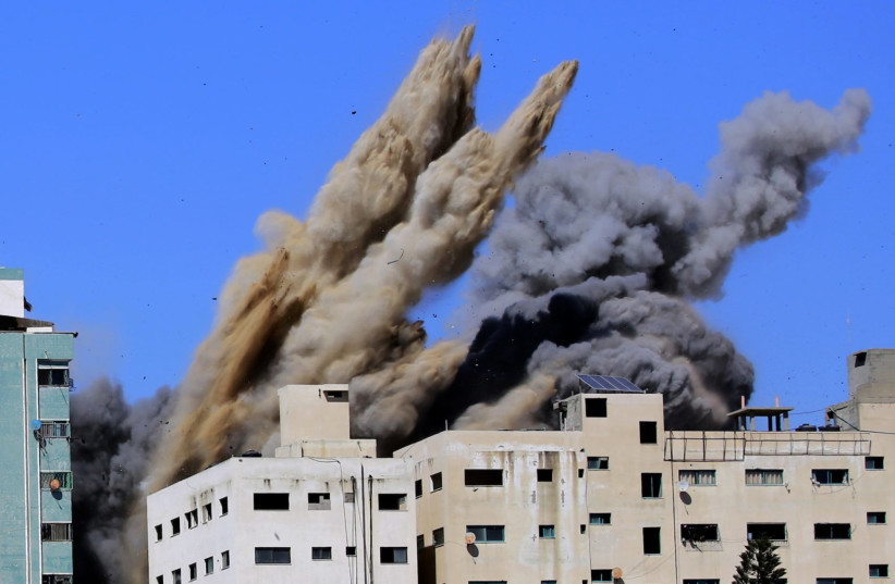  Smoke rises from the Al-Jalaa tower in Gaza City, which housed apartments and several media outlets, including The Associated Press and Al Jazeera, after an Israeli airstrike, May 15, 2021.  (credit: ATIA MOHAMMED/FLASH90)