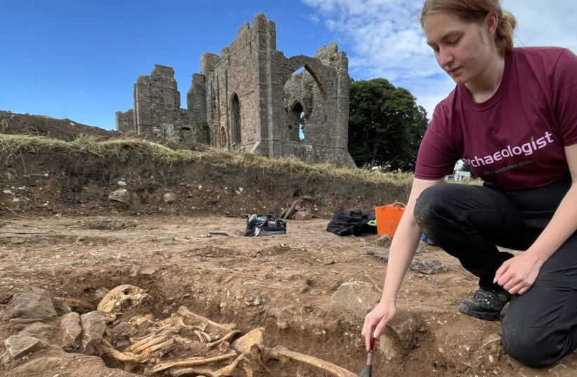  An archaeologist carefully exposes a burial on the site of the early medieval monastery on Lindisfarne. The site also includes the remains of early buildings and religious sculptures (photo credit: DIGVENTURES)