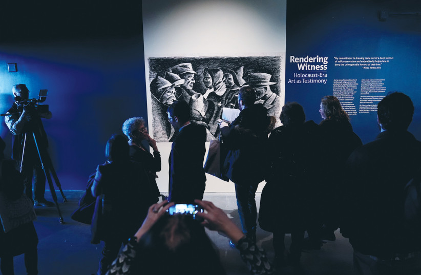  VISITORS VIEW the ‘Rendering Witness’ exhibition at the Museum of Jewish Heritage in New York City, 2020. It seems many in the US are unaware that Jews have been systematically persecuted and massacred for over 2,000 years, says the writer. (photo credit: CARLO ALLEGRI/REUTERS)