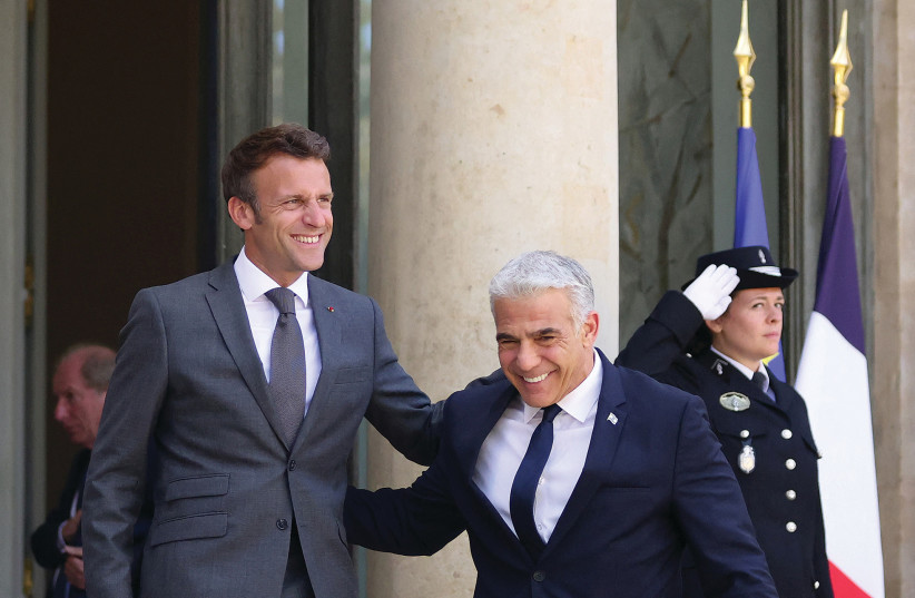  FRENCH PRESIDENT Emmanuel Macron welcomes Prime Minister Yair Lapid as he arrives for a meeting at the Élysée Palace in Paris, this week.  (photo credit: JOHANNA GERON/REUTERS)