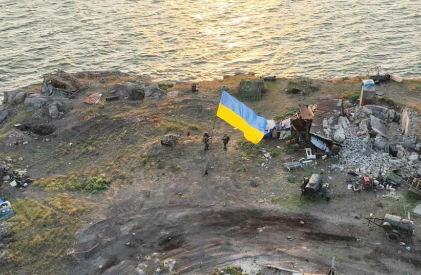  Ukrainian service members install a national flag on Snake (Zmiinyi) Island, as Russia's attack on Ukraine continues, in Odesa region, Ukraine, in this handout picture released July 7, 2022.  (photo credit: UKRAINIAN ARMED FORCES/HANDOUT VIA REUTERS)