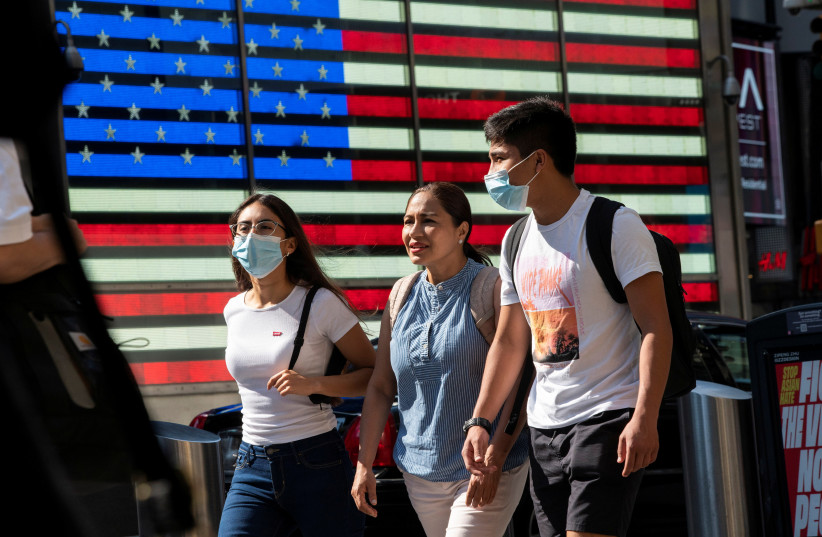  People wear masks around Times Square, as cases of the infectious coronavirus Delta variant continue to rise in New York City, New York, US, July 23, 2021 (photo credit: REUTERS/EDUARDO MUNOZ)