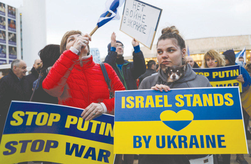  PROTESTORS HOLD signs at a demonstration supporting Ukraine, before Ukrainian President Volodymyr Zelensky’s video speech to the Knesset, in March.  (photo credit: CORINNA KERN/REUTERS)