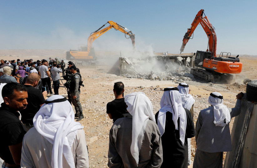  People gather as Israeli machineries demolish a Palestinian house in Masafer Yatta, in the West Bank July 4, 2022.  (photo credit: REUTERS/MUSSA QAWASMA)
