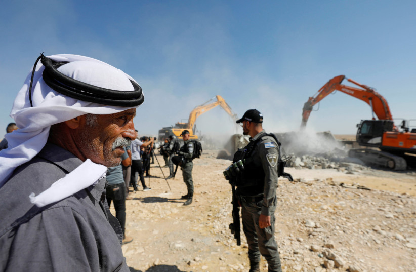  A Palestinian man looks on as Israeli machineries guarded by Israeli forces demolishe a Palestinian house in Masafer Yatta, in the West Bank July 4, 2022 (credit: REUTERS/MUSSA QAWASMA)