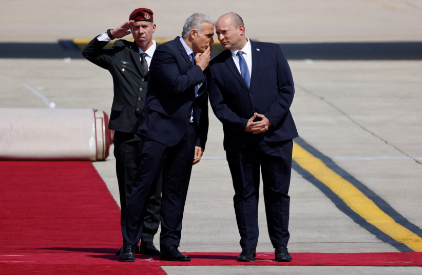  Prime Minister Yair Lapid and Israel's former Prime Minister Naftali Bennett prepare to welcome U.S. President Joe Biden as he lands for a three-day visit, at Ben Gurion International Airport in Lod near Tel Aviv, Israel, July 13, 2022 (credit: REUTERS/AMIR COHEN)