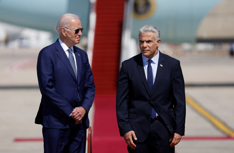 Prime Minister Yair Lapid welcomes US President Joe Biden as he lands for a three-day visit, at Ben Gurion International Airport in Lod near Tel Aviv, Israel, July 13, 2022 (photo credit: REUTERS/IBRAHEEM ABU MUSTAFA)