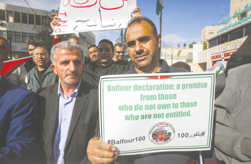  PALESTINIANS PROTEST in Hebron, marking the 100th anniversary of the Balfour Declaration, November 2, 2017. It would be great if the British were to issue a belated correction, saying they support a home for the Jewish people and the Palestinian people, says the writer.  (photo credit: WISAM HASHLAMOUN/FLASH90)