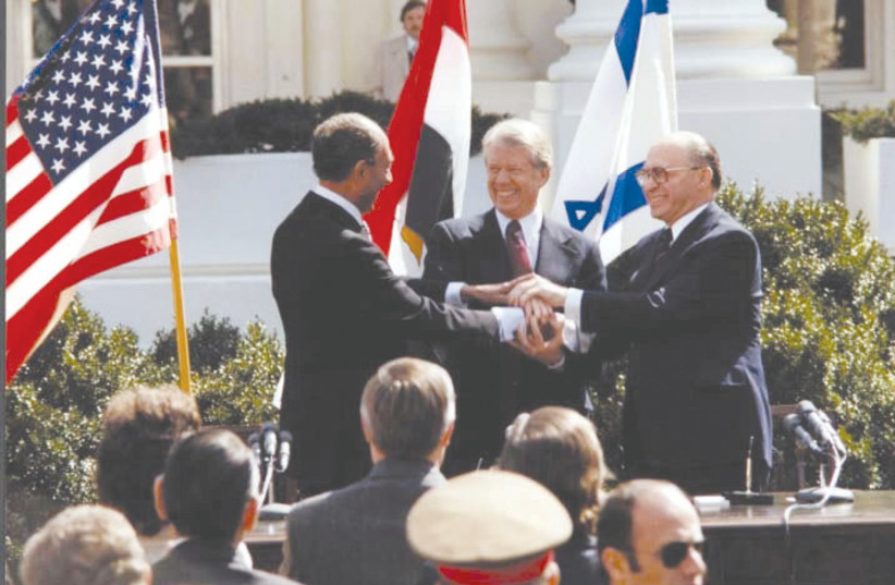 EGYPTIAN, US and Israeli leaders Anwar Sadat, Jimmy Carter and Menachem Begin celebrate the signing of the Israel-Egypt peace treaty, at the White House, in 1979. (photo credit: JIMMY CARTER LIBRARY/NATIONAL ARCHIVES/REUTERS)