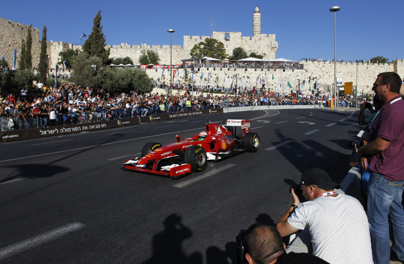  Formula One driver Giancarlo Fisichella drives a Ferrari F60 as the Tower of David in Jerusalem's Old City is seen in the background during an road show in Jerusalem June 13, 2013 (photo credit: REUTERS/BAZ RATNER)